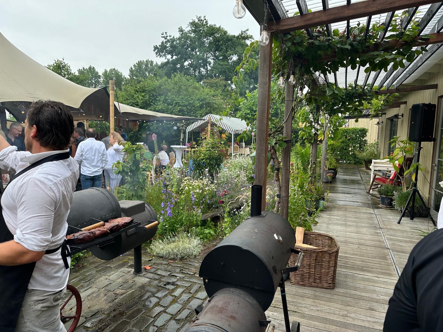 Onze koks grillen op de smoker tijdens een tuinfeest tussen de bloemen