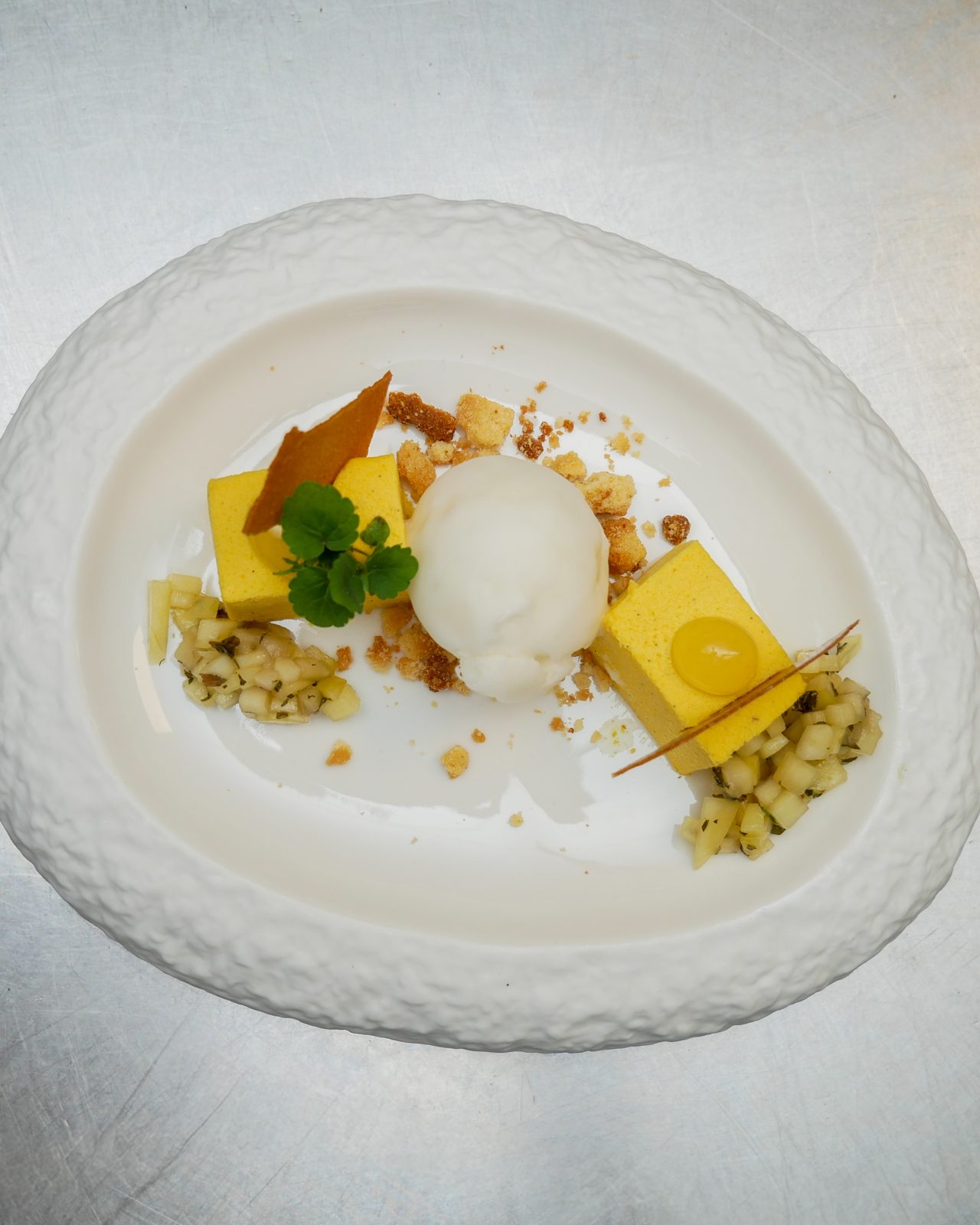 Een fijn opgemaakt dessert op een wit bord uit de keuken van De Vriend