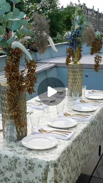 Een gedekte tafel met bloemen en glaswerk aan boord van Sloep de Vriend